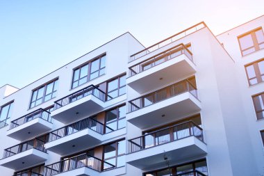 Güneş ışınları kentsel binalar üzerinde ışık etkisi yaratıyor. Düz binaları olan modern bir apartman dairesi. Yeni lüks ev ve ev kompleksinin ayrıntıları. 