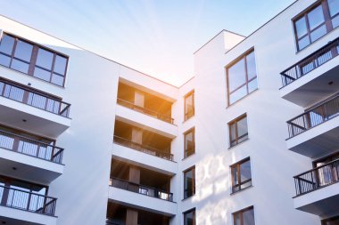 Güneş ışınları kentsel binalar üzerinde ışık etkisi yaratıyor. Düz binaları olan modern bir apartman dairesi. Yeni lüks ev ve ev kompleksinin ayrıntıları. 