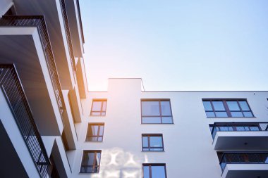Güneş ışınları kentsel binalar üzerinde ışık etkisi yaratıyor. Düz binaları olan modern bir apartman dairesi. Yeni lüks ev ve ev kompleksinin ayrıntıları. 
