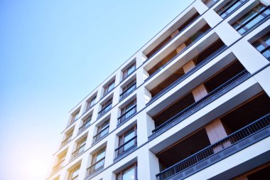 Güneş ışınları kentsel binalar üzerinde ışık etkisi yaratıyor. Düz binaları olan modern bir apartman dairesi. Yeni lüks ev ve ev kompleksinin ayrıntıları. 