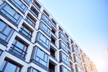 Güneş ışınları kentsel binalar üzerinde ışık etkisi yaratıyor. Düz binaları olan modern bir apartman dairesi. Yeni lüks ev ve ev kompleksinin ayrıntıları. 
