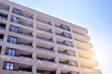 Güneş ışınları kentsel binalar üzerinde ışık etkisi yaratıyor. Düz binaları olan modern bir apartman dairesi. Yeni lüks ev ve ev kompleksinin ayrıntıları. 