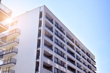 Güneş ışınları kentsel binalar üzerinde ışık etkisi yaratıyor. Düz binaları olan modern bir apartman dairesi. Yeni lüks ev ve ev kompleksinin ayrıntıları. 
