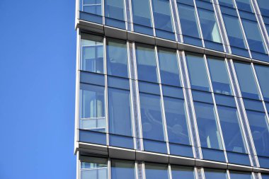 Çelik ve cam mavi gökyüzü ile modern ofis binası duvar yapılmış