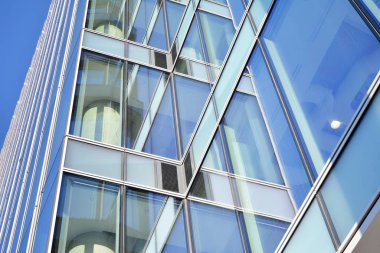 Çelik ve cam mavi gökyüzü ile modern ofis binası duvar yapılmış