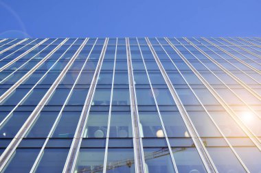 Güneş ışınları kentsel binalar üzerinde ışık etkisi yaratıyor. Modern ofis inşaatı, güneş ışığıyla kaplı cam yüzey. İş geçmişi. 