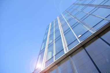Güneş ışınları kentsel binalar üzerinde ışık etkisi yaratıyor. Modern ofis inşaatı, güneş ışığıyla kaplı cam yüzey. İş geçmişi. 