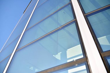 Çelik ve cam mavi gökyüzü ile modern ofis binası duvar yapılmış