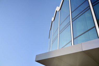 Çelik ve cam mavi gökyüzü ile modern ofis binası duvar yapılmış