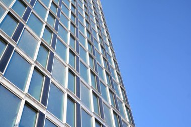 Çelik ve cam mavi gökyüzü ile modern ofis binası duvar yapılmış