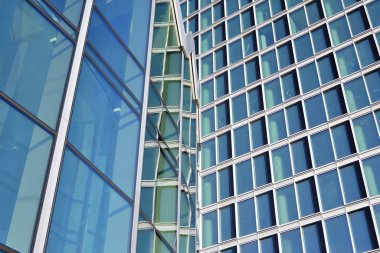 Çelik ve cam mavi gökyüzü ile modern ofis binası duvar yapılmış