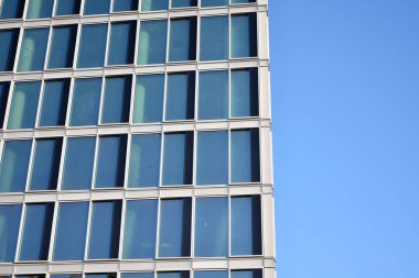 Çelik ve cam mavi gökyüzü ile modern ofis binası duvar yapılmış