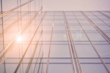Güneş ışığı günbatımında kentsel binalar üzerinde ışık etkisi yaratır. Modern ofis inşaatı, güneş ışığıyla kaplı cam yüzey. İş geçmişi. 