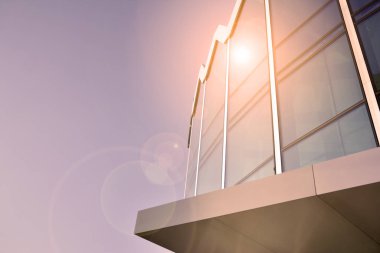 Güneş ışığı günbatımında kentsel binalar üzerinde ışık etkisi yaratır. Modern ofis inşaatı, güneş ışığıyla kaplı cam yüzey. İş geçmişi. 