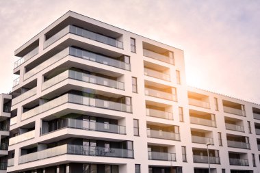 Güneş ışınları kentsel binalar üzerinde ışık etkisi yaratıyor. Düz binaları olan modern bir apartman dairesi. Yeni lüks ev ve ev kompleksinin ayrıntıları. 
