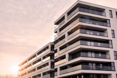 Güneş ışınları kentsel binalar üzerinde ışık etkisi yaratıyor. Düz binaları olan modern bir apartman dairesi. Yeni lüks ev ve ev kompleksinin ayrıntıları. 