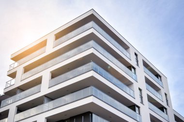 Güneş ışınları kentsel binalar üzerinde ışık etkisi yaratıyor. Düz binaları olan modern bir apartman dairesi. Yeni lüks ev ve ev kompleksinin ayrıntıları. 