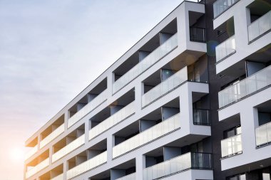 Güneş ışınları kentsel binalar üzerinde ışık etkisi yaratıyor. Düz binaları olan modern bir apartman dairesi. Yeni lüks ev ve ev kompleksinin ayrıntıları. 
