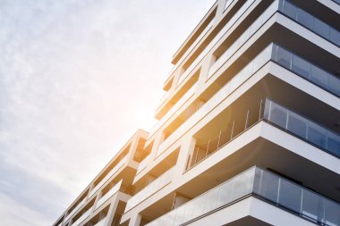 Güneş ışınları kentsel binalar üzerinde ışık etkisi yaratıyor. Düz binaları olan modern bir apartman dairesi. Yeni lüks ev ve ev kompleksinin ayrıntıları. 