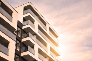 Güneş ışınları kentsel binalar üzerinde ışık etkisi yaratıyor. Düz binaları olan modern bir apartman dairesi. Yeni lüks ev ve ev kompleksinin ayrıntıları. 