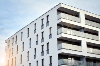 Güneş ışınları kentsel binalar üzerinde ışık etkisi yaratıyor. Düz binaları olan modern bir apartman dairesi. Yeni lüks ev ve ev kompleksinin ayrıntıları. 