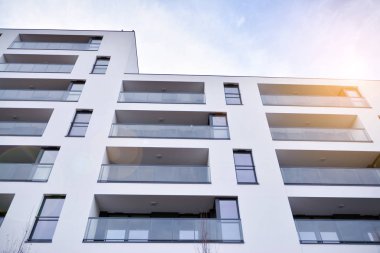 Güneş ışınları kentsel binalar üzerinde ışık etkisi yaratıyor. Düz binaları olan modern bir apartman dairesi. Yeni lüks ev ve ev kompleksinin ayrıntıları. 