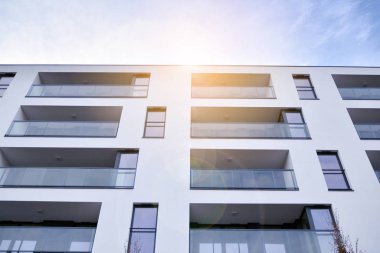 Güneş ışınları kentsel binalar üzerinde ışık etkisi yaratıyor. Düz binaları olan modern bir apartman dairesi. Yeni lüks ev ve ev kompleksinin ayrıntıları. 