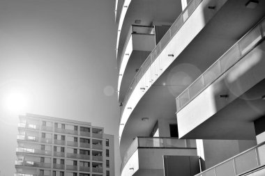 Güneş ışınları kentsel binalar üzerinde ışık etkisi yaratıyor. Düz binaları olan modern bir apartman dairesi. Yeni lüks ev ve kompleksin ayrıntıları. Siyah ve beyaz.