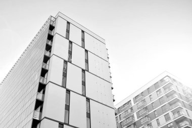 Güneş ışınları kentsel binalar üzerinde ışık etkisi yaratıyor. Düz binaları olan modern bir apartman dairesi. Yeni lüks ev ve kompleksin ayrıntıları. Siyah ve beyaz.