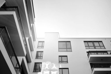 Güneş ışınları kentsel binalar üzerinde ışık etkisi yaratıyor. Düz binaları olan modern bir apartman dairesi. Yeni lüks ev ve kompleksin ayrıntıları. Siyah ve beyaz.