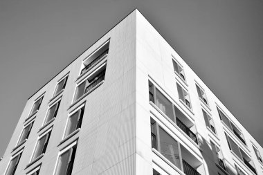 Güneş ışınları kentsel binalar üzerinde ışık etkisi yaratıyor. Düz binaları olan modern bir apartman dairesi. Yeni lüks ev ve kompleksin ayrıntıları. Siyah ve beyaz.