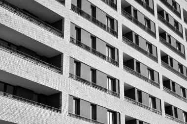 Güneş ışınları kentsel binalar üzerinde ışık etkisi yaratıyor. Düz binaları olan modern bir apartman dairesi. Yeni lüks ev ve kompleksin ayrıntıları. Siyah ve beyaz.