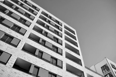 Güneş ışınları kentsel binalar üzerinde ışık etkisi yaratıyor. Düz binaları olan modern bir apartman dairesi. Yeni lüks ev ve kompleksin ayrıntıları. Siyah ve beyaz.