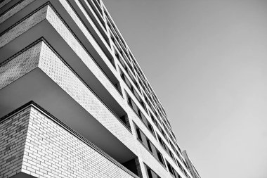 Güneş ışınları kentsel binalar üzerinde ışık etkisi yaratıyor. Düz binaları olan modern bir apartman dairesi. Yeni lüks ev ve kompleksin ayrıntıları. Siyah ve beyaz.