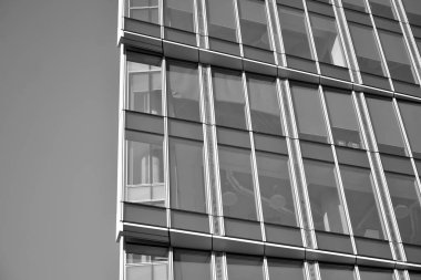 Güneş ışığı günbatımında kentsel binalar üzerinde ışık etkisi yaratır. Modern ofis inşaatı, güneş ışığıyla kaplı cam yüzey. İş geçmişi. Siyah ve beyaz.