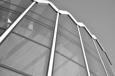 Güneş ışığı günbatımında kentsel binalar üzerinde ışık etkisi yaratır. Modern ofis inşaatı, güneş ışığıyla kaplı cam yüzey. İş geçmişi. Siyah ve beyaz.