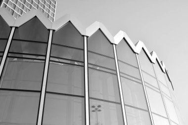 Güneş ışığı günbatımında kentsel binalar üzerinde ışık etkisi yaratır. Modern ofis inşaatı, güneş ışığıyla kaplı cam yüzey. İş geçmişi. Siyah ve beyaz.