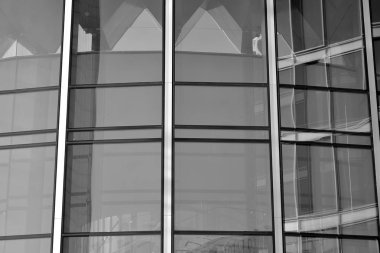 Güneş ışığı günbatımında kentsel binalar üzerinde ışık etkisi yaratır. Modern ofis inşaatı, güneş ışığıyla kaplı cam yüzey. İş geçmişi. Siyah ve beyaz.