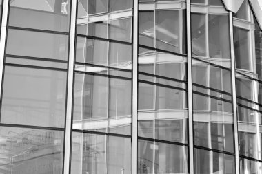 Güneş ışığı günbatımında kentsel binalar üzerinde ışık etkisi yaratır. Modern ofis inşaatı, güneş ışığıyla kaplı cam yüzey. İş geçmişi. Siyah ve beyaz.