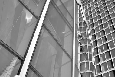 Güneş ışığı günbatımında kentsel binalar üzerinde ışık etkisi yaratır. Modern ofis inşaatı, güneş ışığıyla kaplı cam yüzey. İş geçmişi. Siyah ve beyaz.