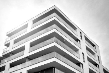 Güneş ışınları kentsel binalar üzerinde ışık etkisi yaratıyor. Düz binaları olan modern bir apartman dairesi. Yeni lüks ev ve kompleksin ayrıntıları. Siyah ve beyaz.