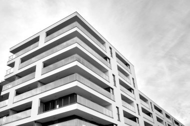 Güneş ışınları kentsel binalar üzerinde ışık etkisi yaratıyor. Düz binaları olan modern bir apartman dairesi. Yeni lüks ev ve kompleksin ayrıntıları. Siyah ve beyaz.