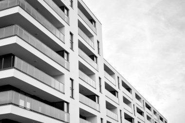 Güneş ışınları kentsel binalar üzerinde ışık etkisi yaratıyor. Düz binaları olan modern bir apartman dairesi. Yeni lüks ev ve kompleksin ayrıntıları. Siyah ve beyaz.