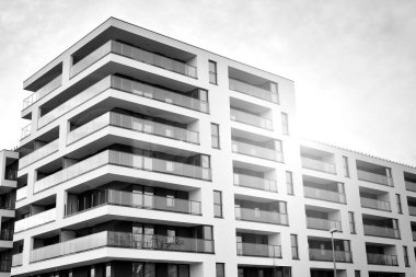 Güneş ışınları kentsel binalar üzerinde ışık etkisi yaratıyor. Düz binaları olan modern bir apartman dairesi. Yeni lüks ev ve kompleksin ayrıntıları. Siyah ve beyaz.