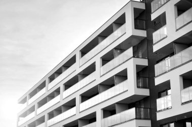 Güneş ışınları kentsel binalar üzerinde ışık etkisi yaratıyor. Düz binaları olan modern bir apartman dairesi. Yeni lüks ev ve kompleksin ayrıntıları. Siyah ve beyaz.