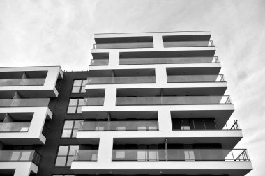 Güneş ışınları kentsel binalar üzerinde ışık etkisi yaratıyor. Düz binaları olan modern bir apartman dairesi. Yeni lüks ev ve kompleksin ayrıntıları. Siyah ve beyaz.