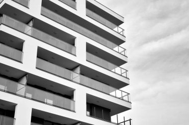 Güneş ışınları kentsel binalar üzerinde ışık etkisi yaratıyor. Düz binaları olan modern bir apartman dairesi. Yeni lüks ev ve kompleksin ayrıntıları. Siyah ve beyaz.