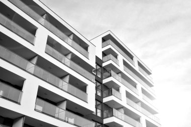 Güneş ışınları kentsel binalar üzerinde ışık etkisi yaratıyor. Düz binaları olan modern bir apartman dairesi. Yeni lüks ev ve kompleksin ayrıntıları. Siyah ve beyaz.