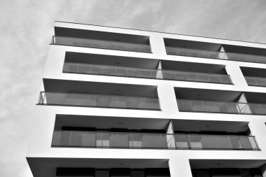 Güneş ışınları kentsel binalar üzerinde ışık etkisi yaratıyor. Düz binaları olan modern bir apartman dairesi. Yeni lüks ev ve kompleksin ayrıntıları. Siyah ve beyaz.