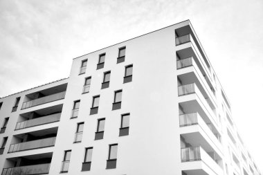 Güneş ışınları kentsel binalar üzerinde ışık etkisi yaratıyor. Düz binaları olan modern bir apartman dairesi. Yeni lüks ev ve kompleksin ayrıntıları. Siyah ve beyaz.